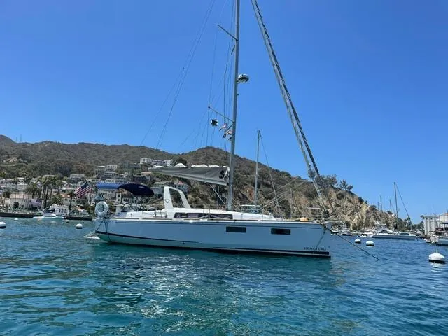 Slide: The Image of 2021 Beneteau Oceanis 35.1 sailboat anchored in a scenic coastal bay. - 4