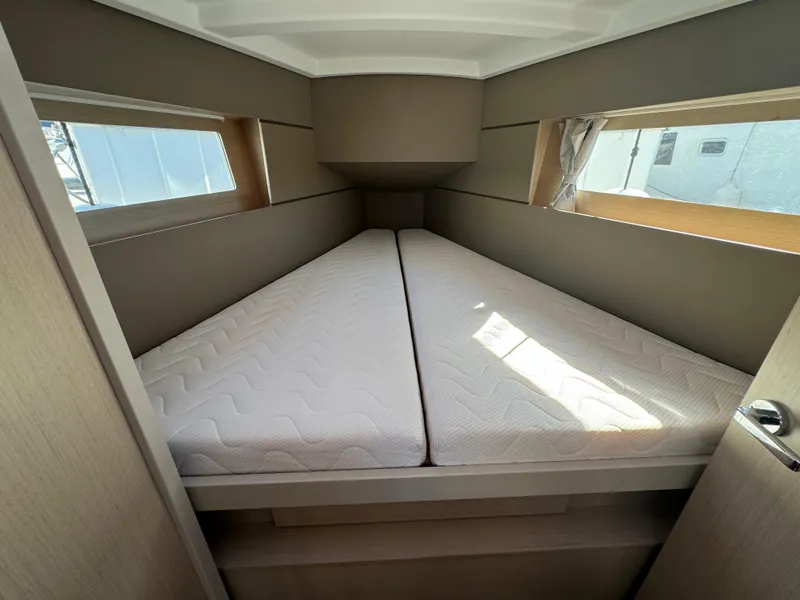 Slide: The Image of Interior cabin of 2021 Beneteau Oceanis 35.1 yacht with twin mattresses and windows. - 40