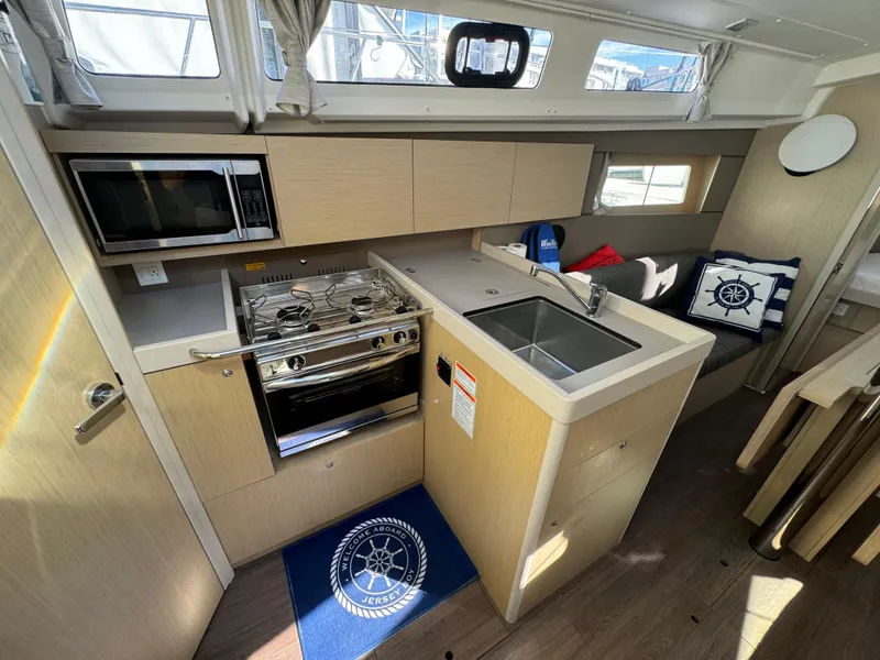 Slide: The Image of Modern kitchen interior of 2021 Beneteau Oceanis 35.1 yacht with stove, sink, and microwave. - 42