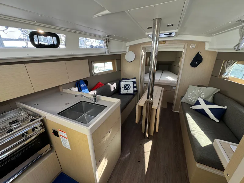 Slide: The Image of Interior of 2021 Beneteau Oceanis 35.1 sailboat, featuring modern kitchen and cozy seating area. - 44