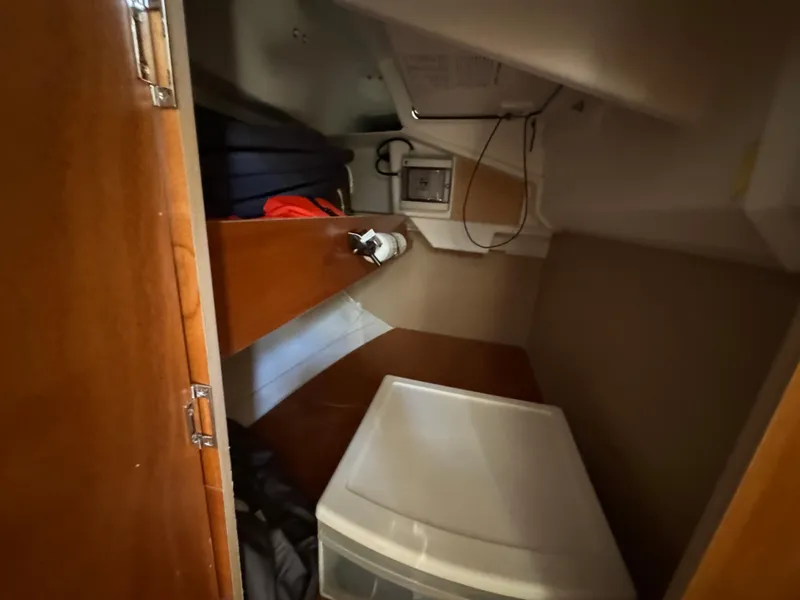 Slide: The Image of Interior cabin storage of 2021 Beneteau Oceanis 35.1 sailboat, featuring wooden cabinetry and storage bins. - 45