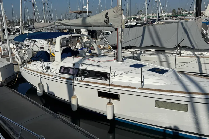 Slide: The Image of 2021 Beneteau Oceanis 35.1 sailboat docked in marina, sunny day, multiple boats in background. - 56