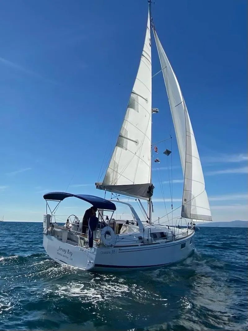 Slide: The Image of 2021 Beneteau Oceanis 35.1 sailing on open sea under clear blue sky. - 9