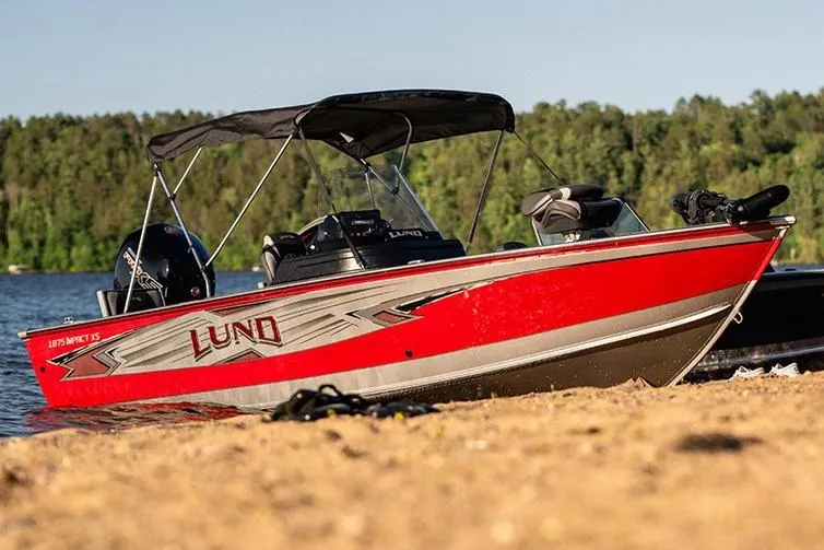 Slide: The Image of 2026 Lund 1875 Impact XS SS boat interior with steering wheel and storage compartments. - 11