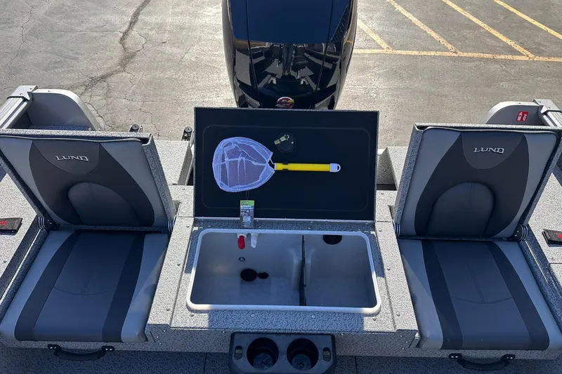 Slide: The Image of 2026 Lund 1875 Impact XS SS boat interior with seats, storage, and fishing net. - 12