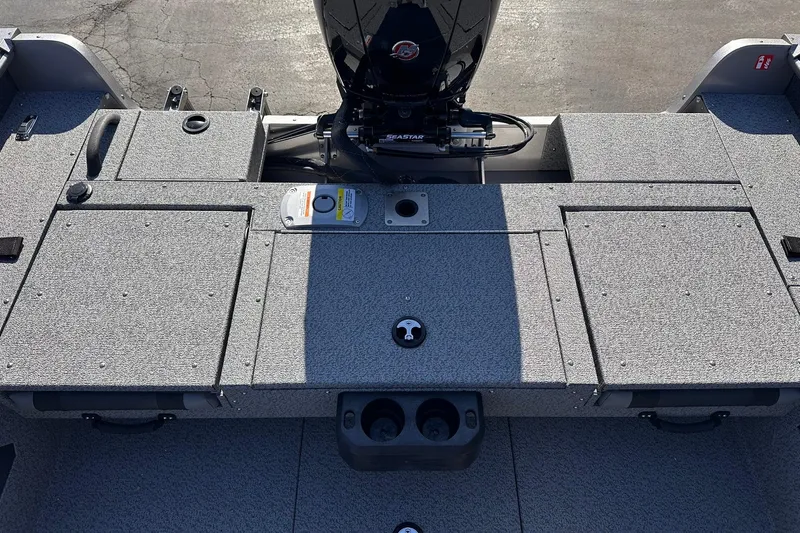 Slide: The Image of 2026 Lund 1875 Impact XS SS boat deck with motor, featuring storage compartments. - 13