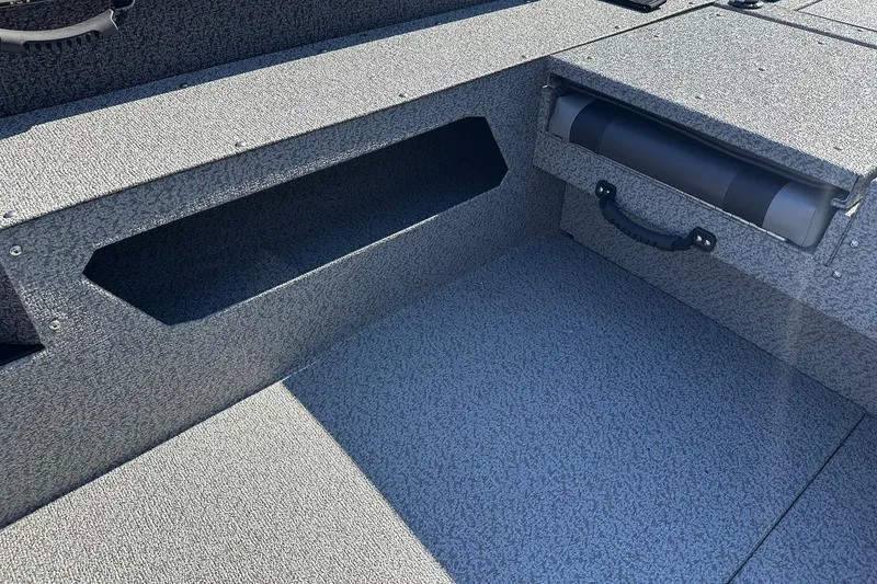 Slide: The Image of 2026 Lund 1875 Impact XS SS boat interior with storage compartments and textured flooring. - 20