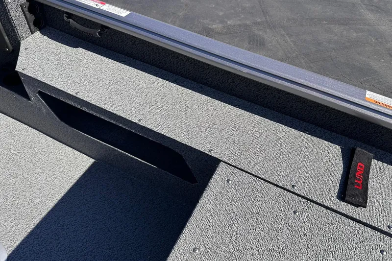 Slide: The Image of 2026 Lund 1875 Impact XS SS boat interior with textured flooring and storage compartment. - 21