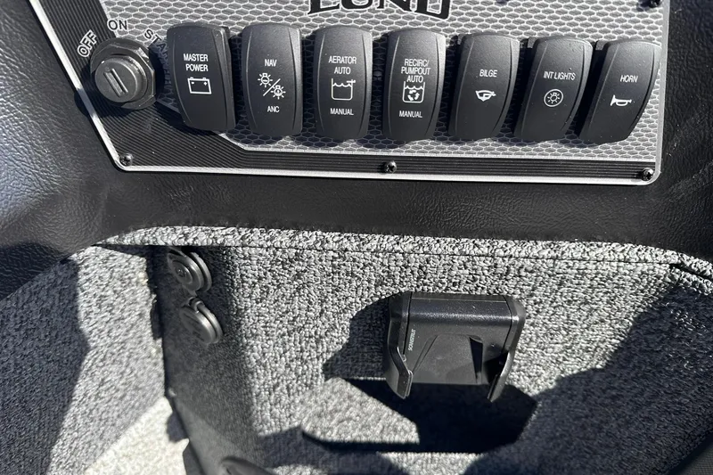 Slide: The Image of Control panel of 2026 Lund 1875 Impact XS SS boat with various switches. - 24