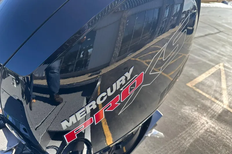 Slide: The Image of Mercury Pro XS engine on 2026 Lund 1875 Impact XS SS boat, reflecting surroundings. - 26