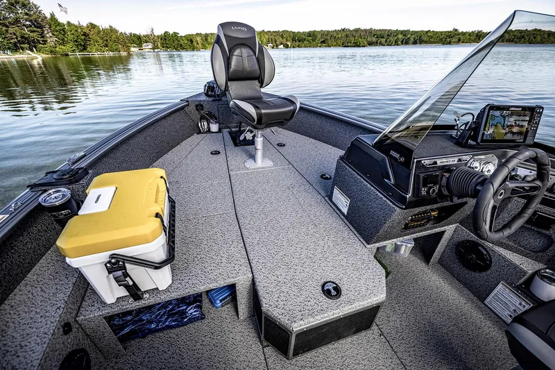 Slide: The Image of 2026 Lund 1875 Impact XS SS boat with Mercury engine, parked outdoors on a sunny day. - 4
