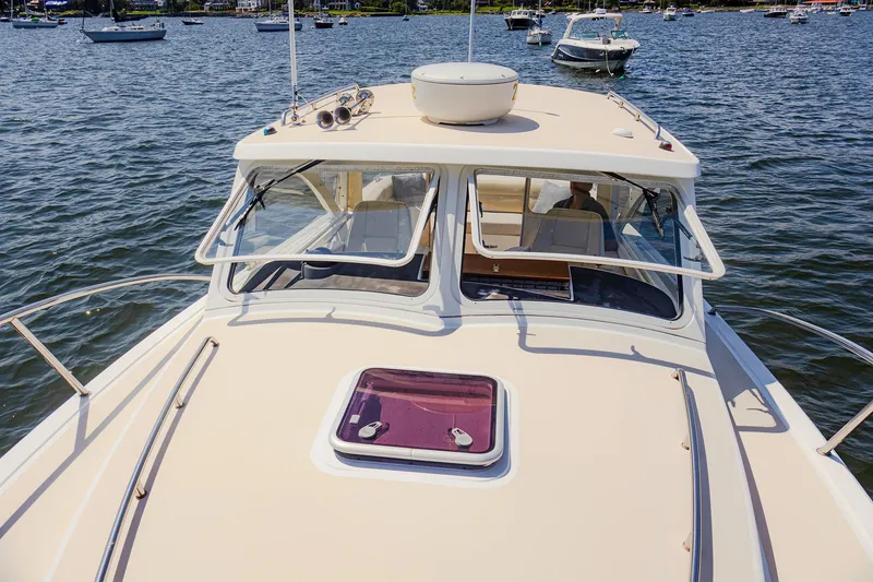 Slide: The Image of 2007 MJM 29z boat on water, front deck view with open windows. - 10