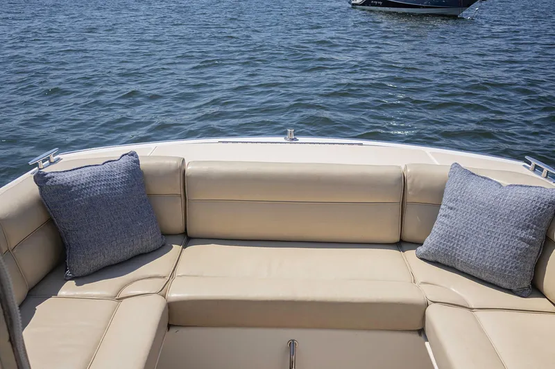Slide: The Image of 2007 MJM 29z boat with beige seating and blue cushions on the water. - 13