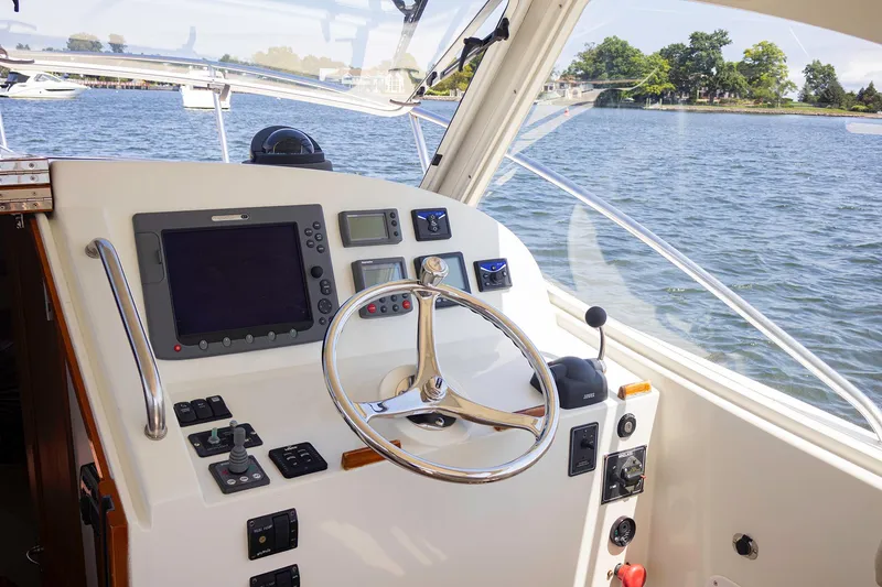 Slide: The Image of 2007 MJM 29z boat helm with steering wheel and navigation controls on a sunny day. - 14
