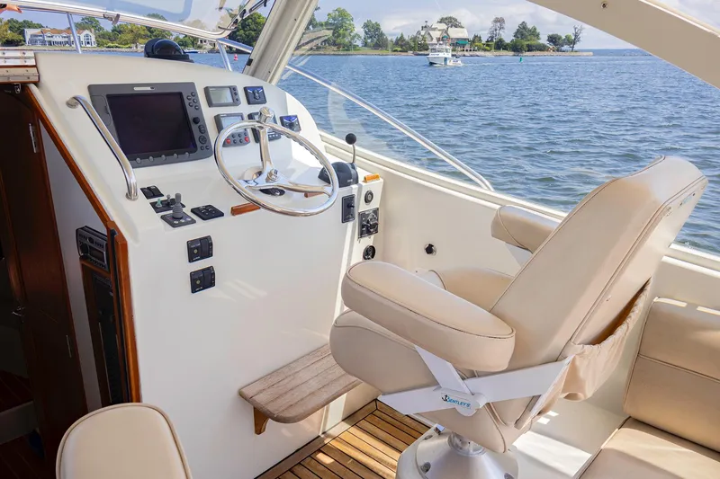Slide: The Image of 2007 MJM 29z boat helm with steering wheel, navigation controls, and captain's chair. - 15