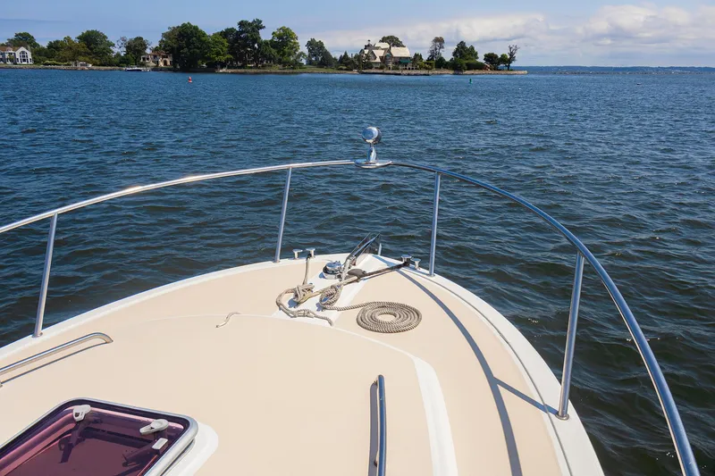 Slide: The Image of Bow of a 2007 MJM 29z boat cruising on a calm lake. - 8