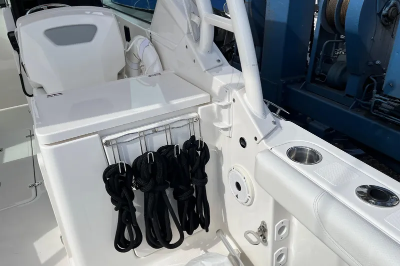 Slide: The Image of 2020 Pursuit DC 266 Dual Console boat interior with storage and cup holders. - 10