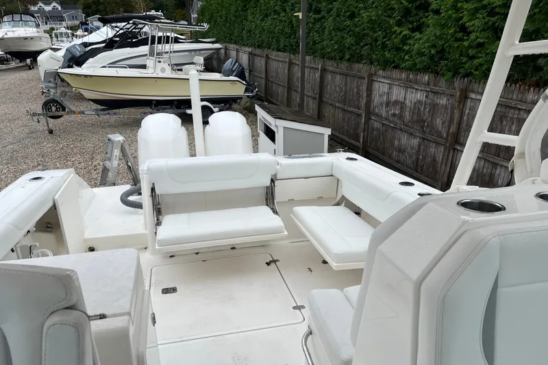 Slide: The Image of 2020 Pursuit DC 266 Dual Console boat interior with white seating and cup holders. - 11