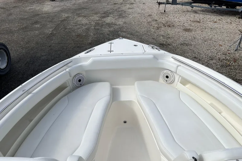 Slide: The Image of 2020 Pursuit DC 266 Dual Console boat with white seating and speakers in the bow area. - 14
