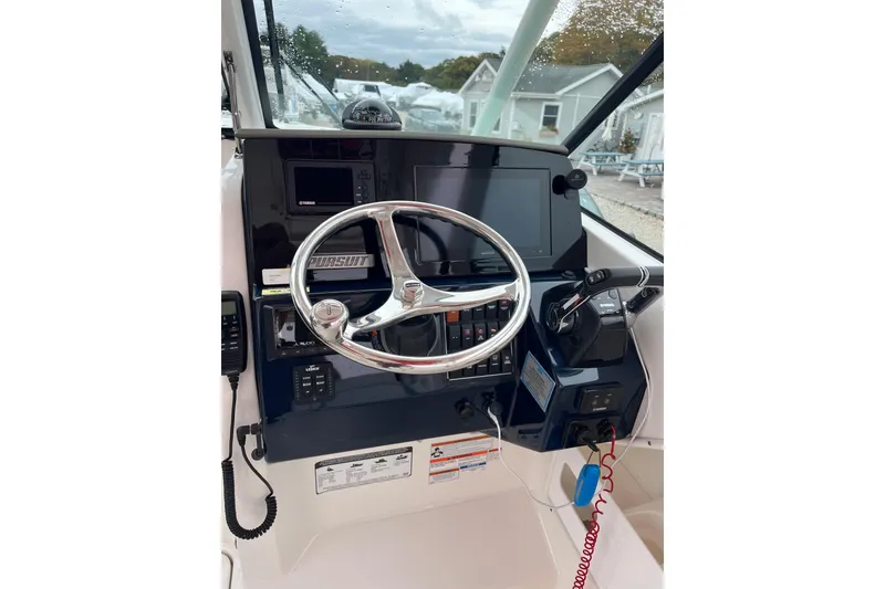 Slide: The Image of 2020 Pursuit DC 266 Dual Console boat dashboard with steering wheel and controls. - 17