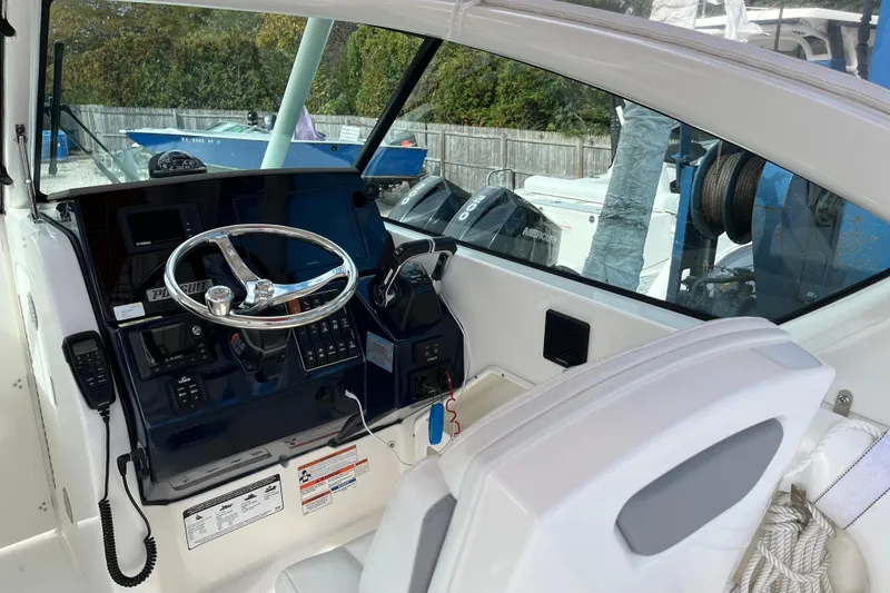 Slide: The Image of 2020 Pursuit DC 266 Dual Console boat cockpit with steering wheel and control panel. - 18