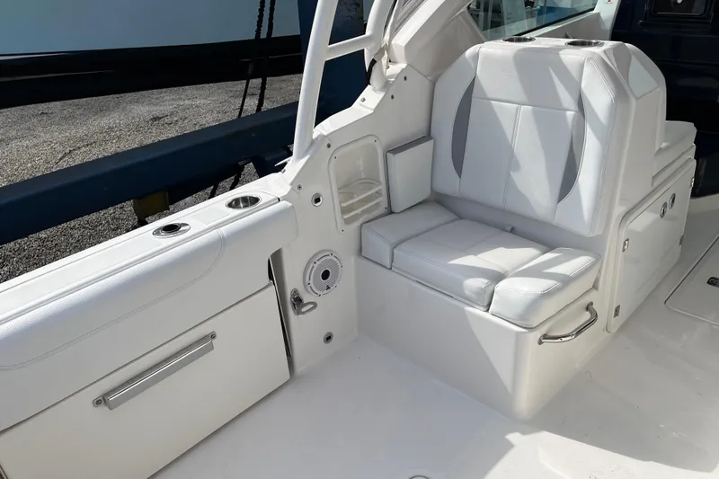 Slide: The Image of 2020 Pursuit DC 266 Dual Console boat interior with white seating and cup holders. - 20