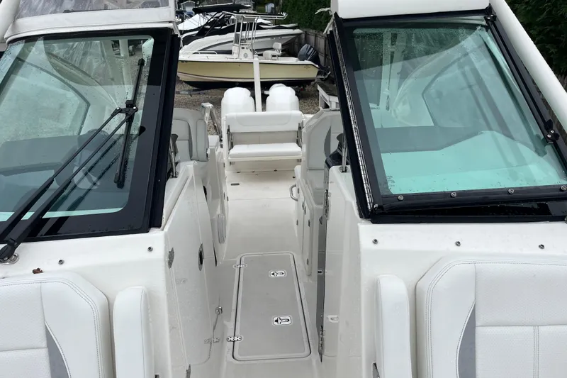 Slide: The Image of 2020 Pursuit DC 266 Dual Console boat interior with windshield and seating. - 21