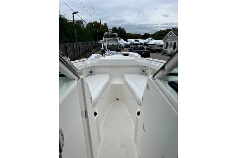 Slide: The Image of 2020 Pursuit DC 266 Dual Console boat interior with white seating and open deck. - 5