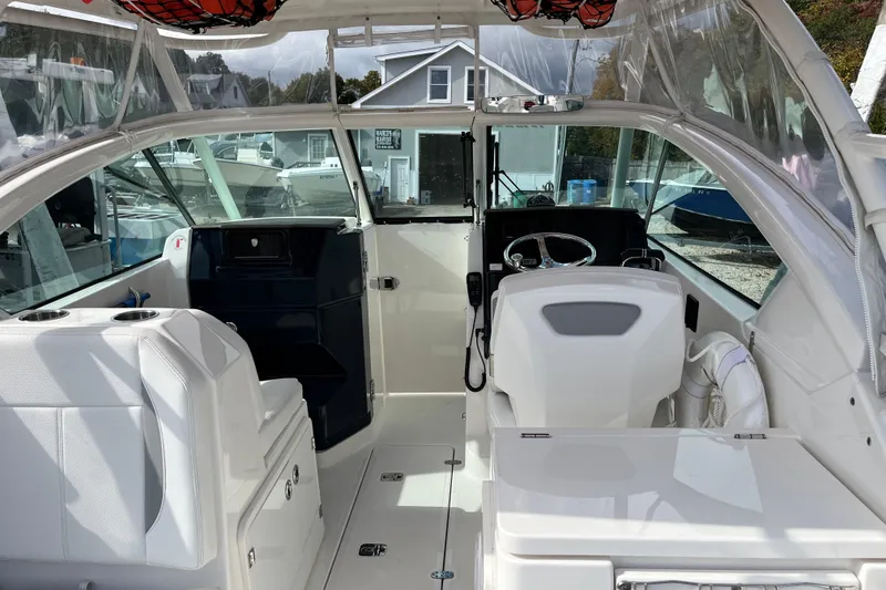Slide: The Image of 2020 Pursuit DC 266 Dual Console boat interior with white seating and steering wheel. - 9