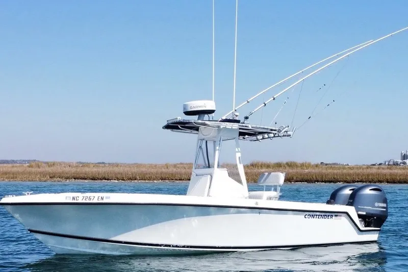 The Image of 1998 Contender 23 Open boat with dual Yamaha engines on calm water. - 1