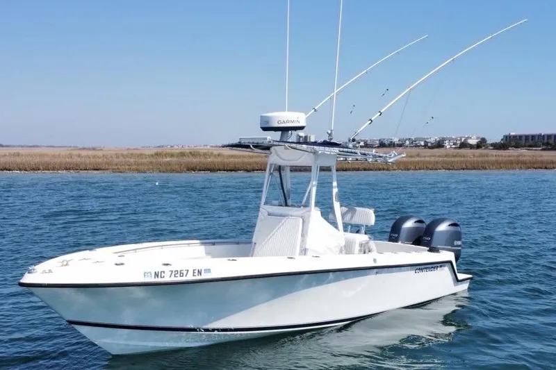 Slide: The Image of 1998 Contender 23 Open boat with dual engines on calm water. - 2