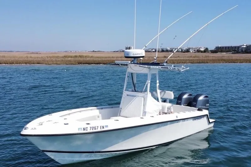 Slide: The Image of 1998 Contender 23 Open boat on water with dual engines and fishing rods. - 3