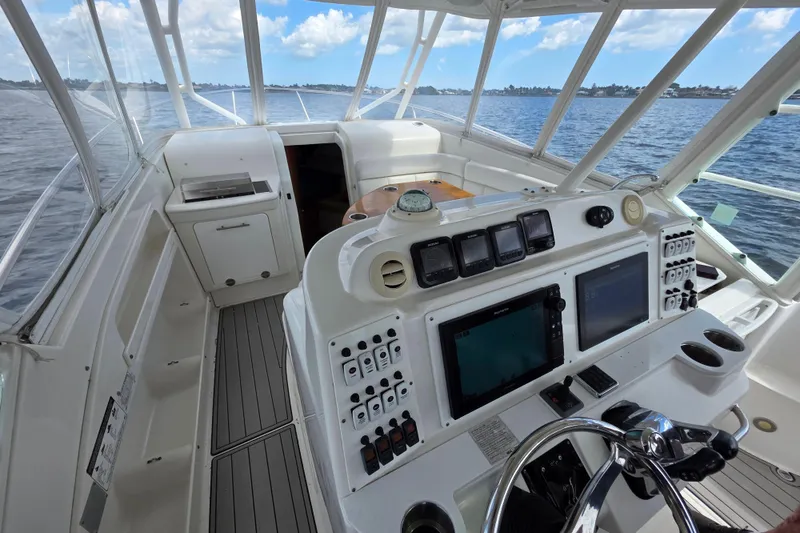 Slide: The Image of 2008 Everglades 350LX boat cockpit with navigation controls, steering wheel, and ocean view. - 12