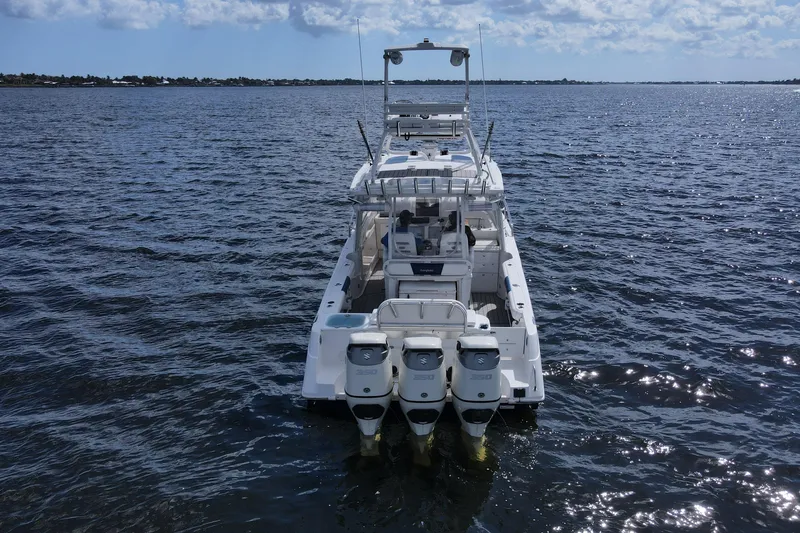 Slide: The Image of 2008 Everglades 350LX boat on open water, rear view with triple engines. - 2