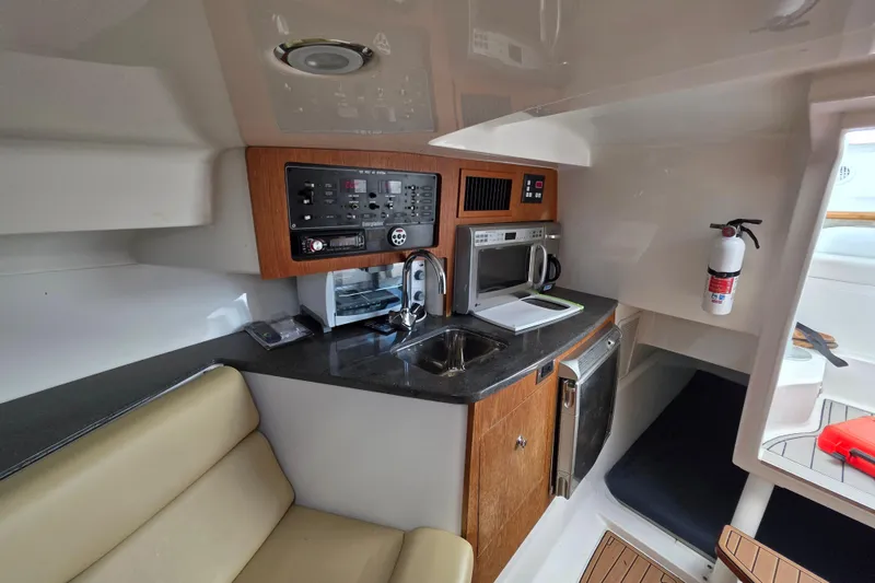 Slide: The Image of Interior of a 2008 Everglades 350LX boat featuring a compact kitchen area. - 24