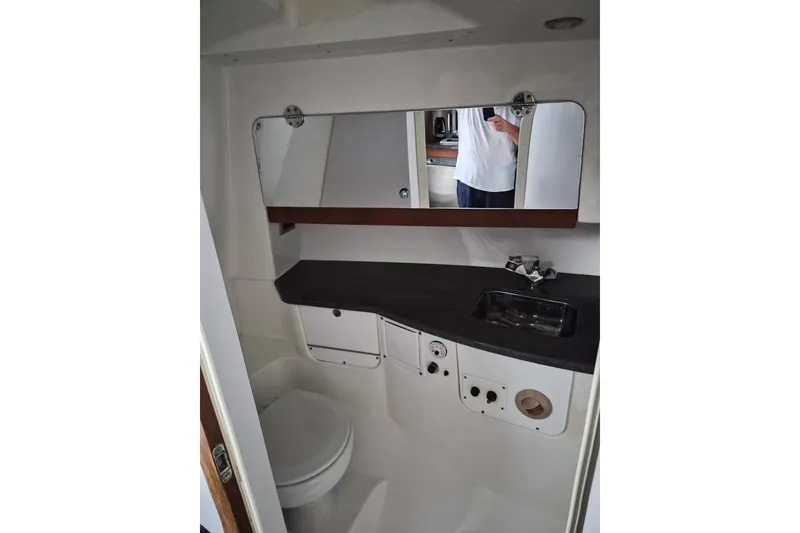 Slide: The Image of 2008 Everglades 350LX boat bathroom interior with sink, mirror, and toilet. - 31