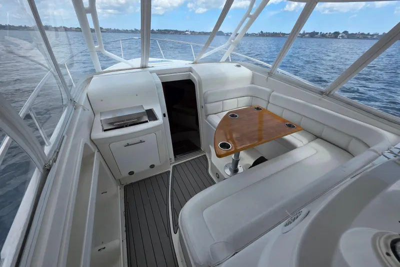 Slide: The Image of 2008 Everglades 350LX boat interior with seating, table, and grill on the water. - 8
