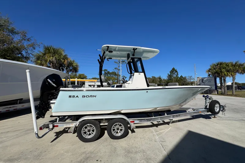 Slide: The Image of 2026 Sea Born LX22 Center Console boat on trailer, parked outdoors under clear blue sky. - 10