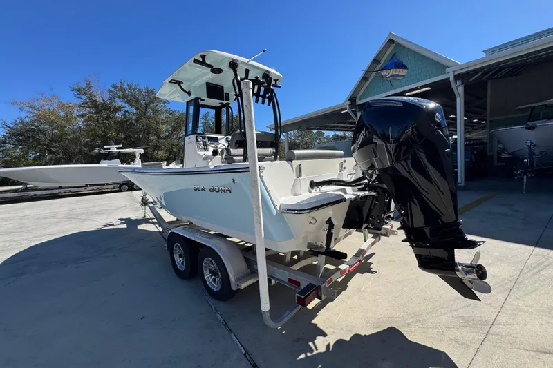 Slide: The Image of 2026 Sea Born LX22 Center Console boat on trailer, parked outdoors under clear sky. - 17