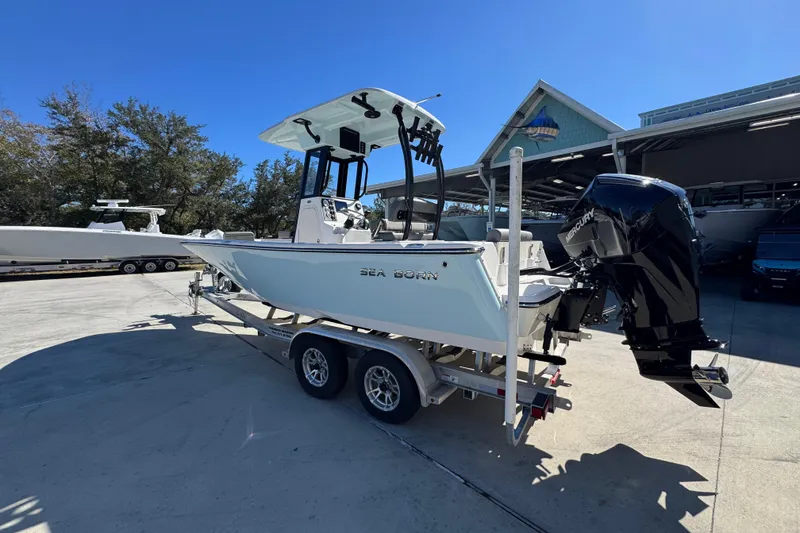 Slide: The Image of 2026 Sea Born LX22 Center Console boat on trailer, parked outdoors under clear blue sky. - 18
