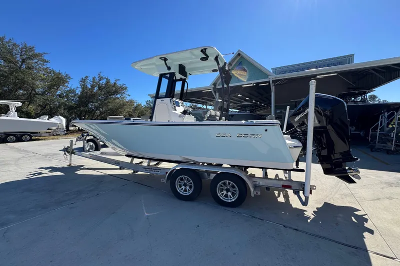 Slide: The Image of 2026 Sea Born LX22 Center Console boat on trailer, parked outdoors under clear sky. - 19