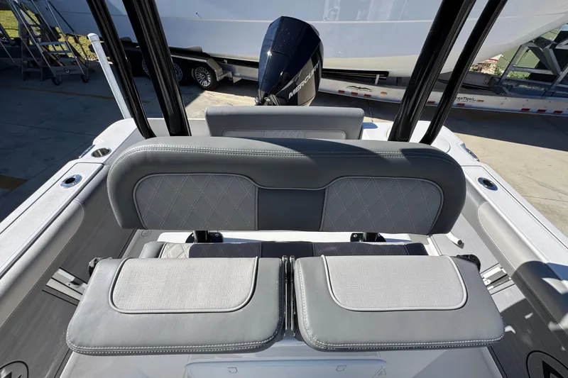 Slide: The Image of 2026 Sea Born LX22 Center Console boat interior with cushioned seating and outboard motor. - 29