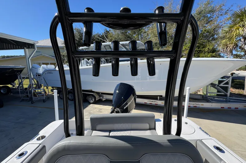 Slide: The Image of 2026 Sea Born LX22 Center Console boat with T-top and outboard motor in a marina setting. - 30