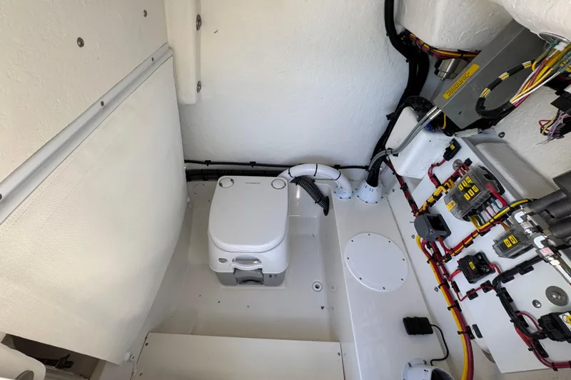 Slide: The Image of 2026 Sea Born LX22 Center Console boat interior with portable toilet and wiring. - 43