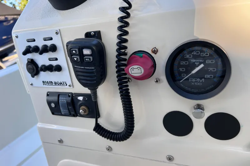 Slide: The Image of Control panel of a 2017 Rigid Boats 14 Sport with gauges and switches. - 14