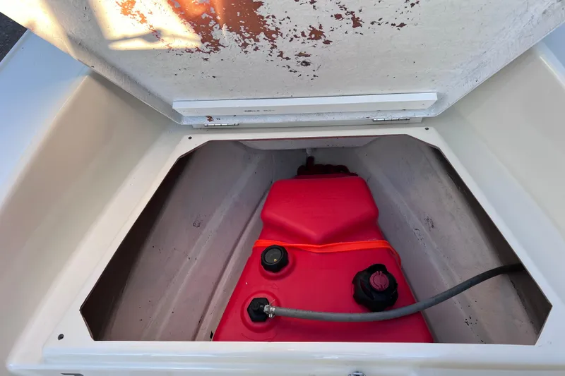 Slide: The Image of 2017 Rigid Boats 14 Sport storage compartment with red fuel tank. - 19