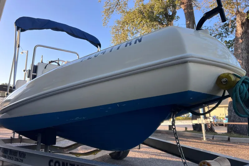 Slide: The Image of 2017 Rigid Boats 14 Sport on trailer, blue and white hull, outdoor setting. - 4
