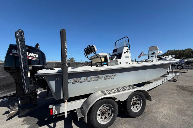 Slide: The Image of 2020 Blazer Bay 2200 Fisherman boat on trailer with Suzuki engine, clear sky background. - 3