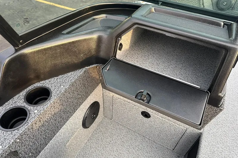 Slide: The Image of 2026 Lund 1875 Impact XS Sport boat interior with storage compartment and cup holders. - 13