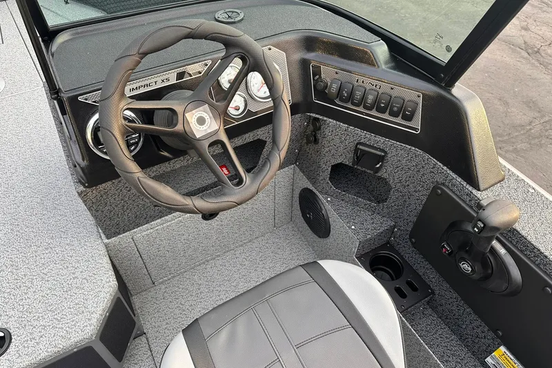 Slide: The Image of 2026 Lund 1875 Impact XS Sport boat cockpit with steering wheel and control panel. - 14